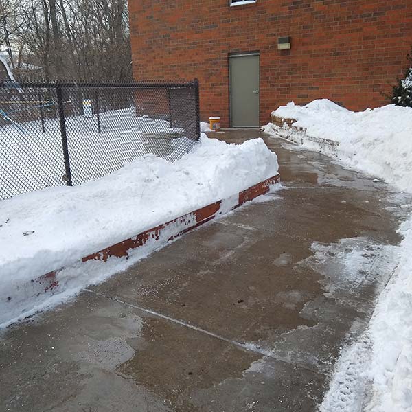 A sidewalk freshly snow plowed